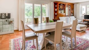 A spacious living room with a large dining table, comfortable seating, a bookshelf, and a television. - Holiday home with private pool near Orange (Lagarde-Paréol)