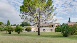 A large tree in front of a building with a balcony. - Holiday home with private pool near Orange (Lagarde-Paréol)
