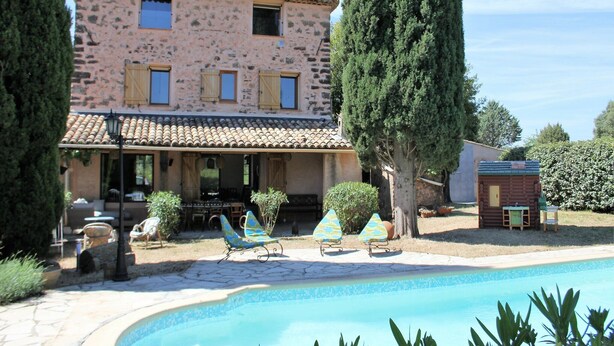 A stone building with a tiled roof, a swimming pool, and outdoor seating. - Private Pool in Provence (La Motte)
