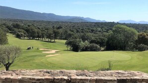 A golf course with a stone wall in the foreground, surrounded by trees and mountains in the background. - Private Pool in Provence (La Motte)