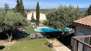 Ein Garten mit Pool, einer kleinen Terrasse und Blick auf einen Berg.