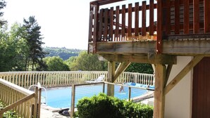 A wooden deck with a pool and a view of the surrounding landscape. - Poolside Bliss Near Lake (Beaulieu)