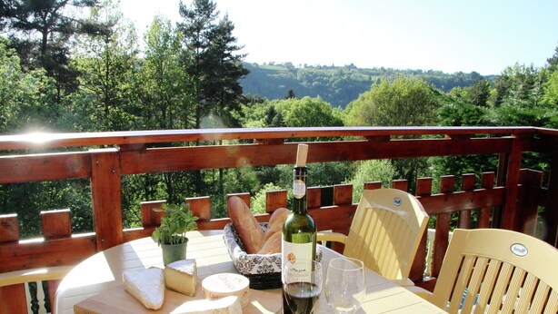 A table set with cheese, bread, wine, and glasses on a balcony with a scenic view. - Poolside Bliss Near Lake (Beaulieu)