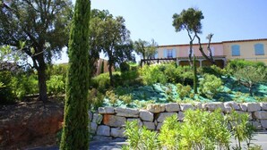 A Mediterranean-style building with a stone wall and lush greenery. - Family-Friendly Villa with Pool (Les Issambres/St. Maxime)