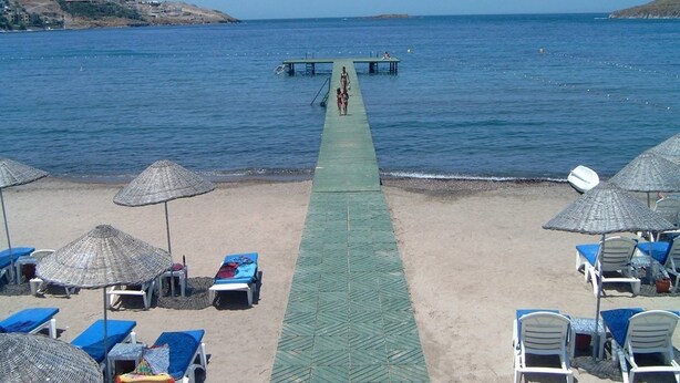 A beach with a pier extending into the sea, lined with umbrellas and lounge chairs. - Family-Friendly Villa with Pool (Les Issambres/St. Maxime)