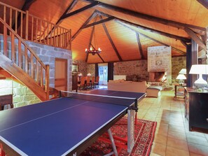 A spacious room with a ping pong table, a stone fireplace, and a cozy seating area. - Charming Farmhouse in Cros-de-Géorand (Cros-De-Géorand)