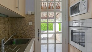Une cuisine équipée d’un évier, d’un four à micro-ondes et d’un four traditionnel.