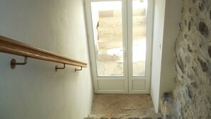 Una escalera de piedra con peldaños que conducen a una puerta con paneles de vidrio.