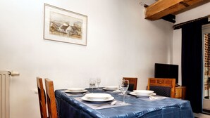 A dining room with a table set for four, a framed picture on the wall, and a window with curtains. - Lovely Holiday Home in Richelle with Barbecue (Richelle)