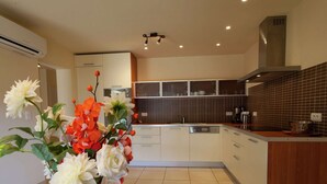 A modern kitchen with a central island, white cabinetry, and a tiled backsplash.