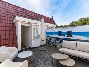 A deck with outdoor seating, a door, and a mural of a beach scene.