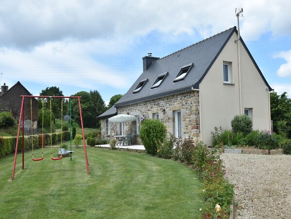 A stone house with a sloped roof, a swing set, and a well-maintained lawn. - Home for 7 Guests in Plouvara (Plouvara)