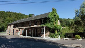 A stone building with a sloped roof, a covered porch, and a small attached shed. - Holiday Home in Borgoumont near Spa Town (La Gleize)