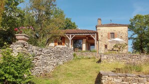 A stone house with a tiled roof, a stone wall, and a covered porch. - Hilltop Home with Valley View (Bouzic)