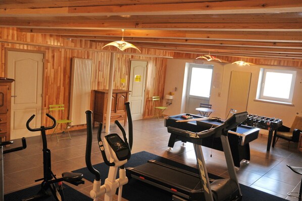 A gym with exercise equipment including treadmills and a foosball table.