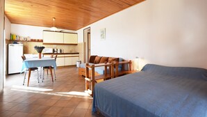 Una stanza compatta con un letto, un tavolo da pranzo e angolo cottura.