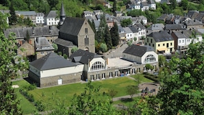 Een stad met een opvallende kerk, een modern gebouw met een gebogen dak en traditionele huizen.