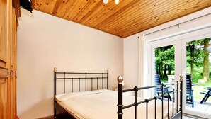 A single bed with a metal frame in a room with wooden flooring and a wooden ceiling. - Wellness Escape in Gouvy (Gouvy)