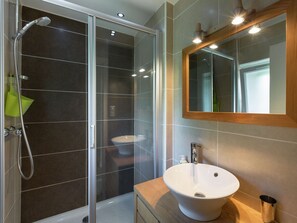 Enjoy a refreshing shower in the bathroom with a glass-enclosed shower and separate sink.