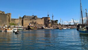 Un port doté de bâtiments historiques, avec un château en arrière-plan.