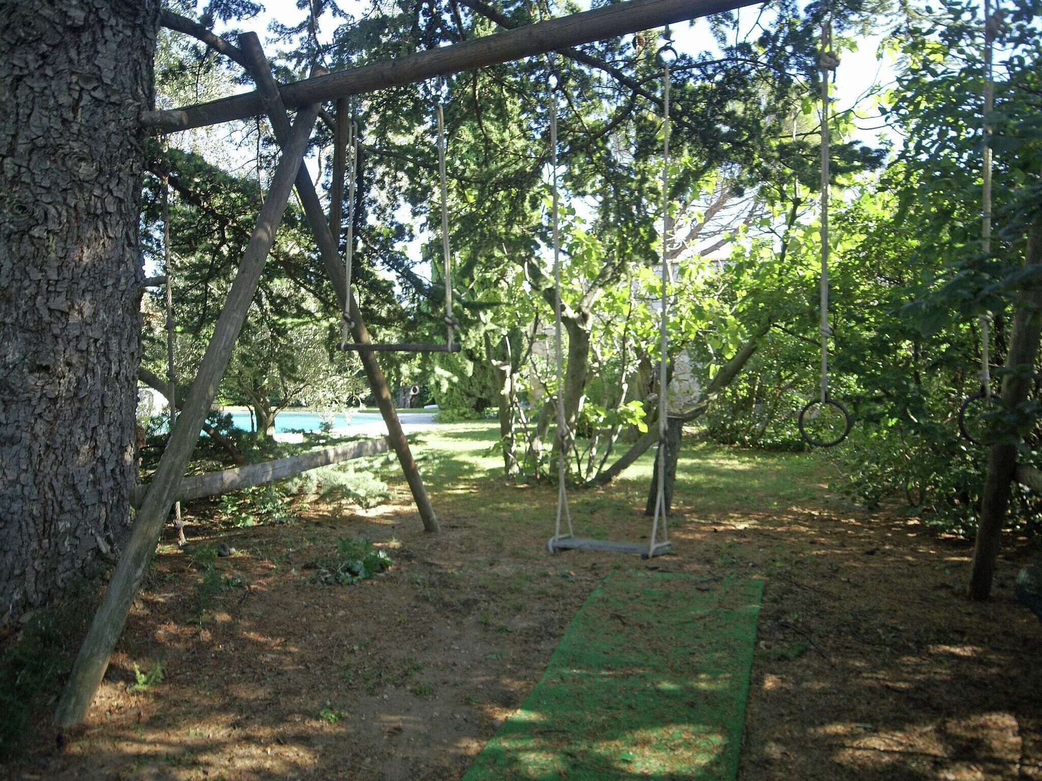 Ein Spielplatz mit Schaukel und einer grünen Matte auf dem Boden.