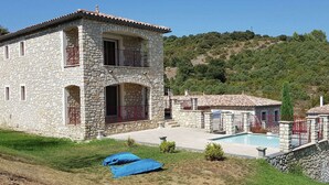 A stone villa with a pool, surrounded by a lush green landscape and hills. - Cosy holiday home with views and private pool (Saint-Ambroix)