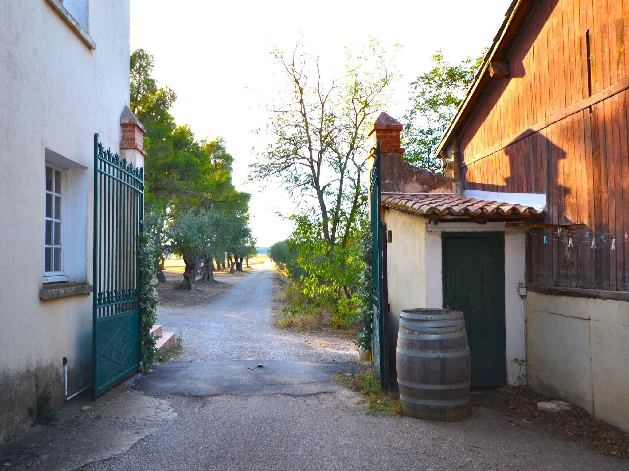 Une ruelle étroite, avec un bâtiment en bois rustique sur la droite et un bâtiment blanc sur la gauche.