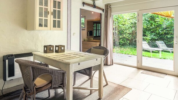 A room with a table and chairs, a cabinet, and a view of the outdoors. - Charming Retreat, Veldegem (Zedelgem - Veldegem)