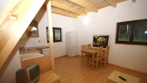 A compact kitchen with a sink, refrigerator, and wooden dining table with chairs. - Chalet in Dabo near Castle Ruins (La Hoube (dabo))