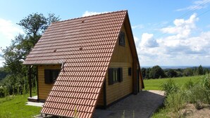 A single-story house with a sloped roof, a small porch, and a view of the countryside. - Chalet in Dabo near Castle Ruins (La Hoube (dabo))