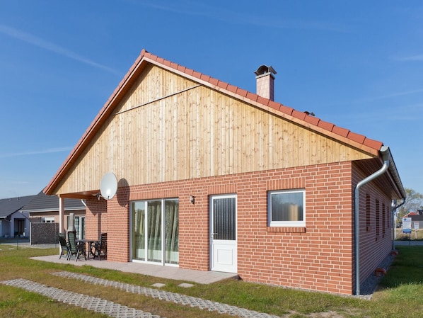 A modern building with a wooden facade and brick lower section, featuring large windows and a satellite dish. - Gemuetliche Unterkunft in Zierow mit Sauna (Zierow)