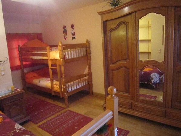 A bedroom with a bunk bed, a wooden wardrobe, and a mirror. - Cottage in Vaires-sur-Marne by Forest Lake (Vaires sur Marne)