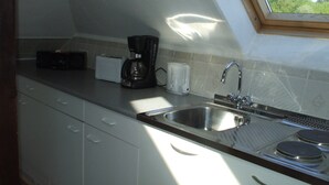 A kitchen with a sink, a toaster, a coffee maker, and a window above the sink. - Apartment in Bad Doberan mit Garten (Bad Doberan)