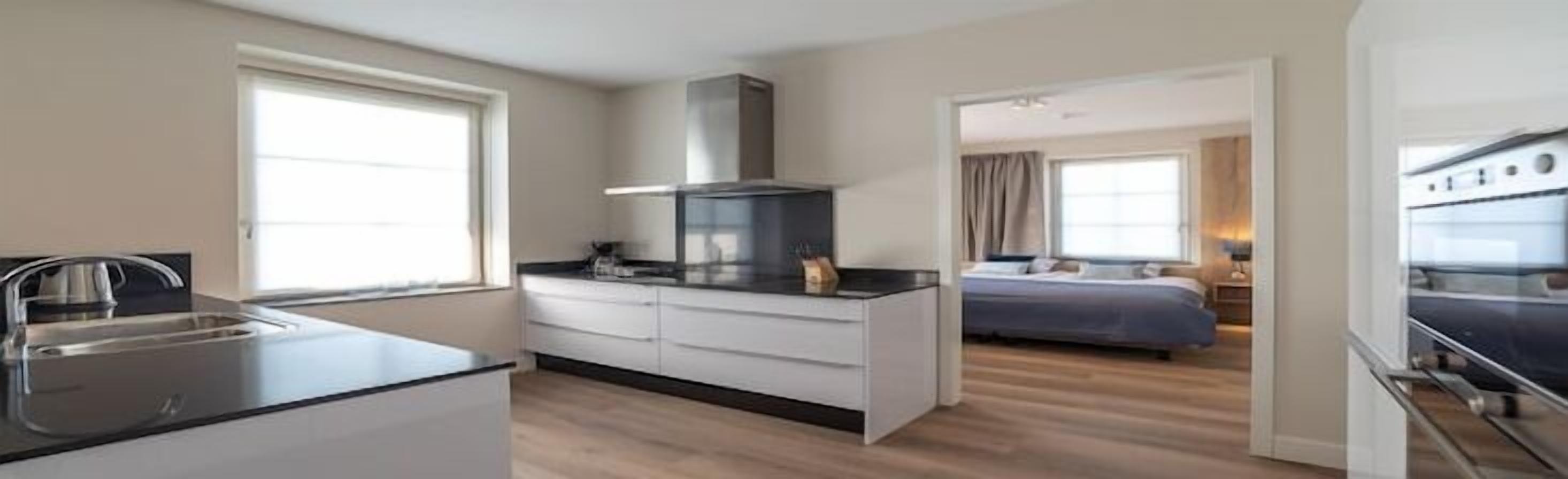 Una cucina compatta e moderna, con piano cottura integrato e una grande finestra.