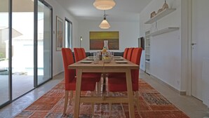 Ein Essbereich mit einem Holztisch, roten Stühlen und einem gemusterten Teppich.