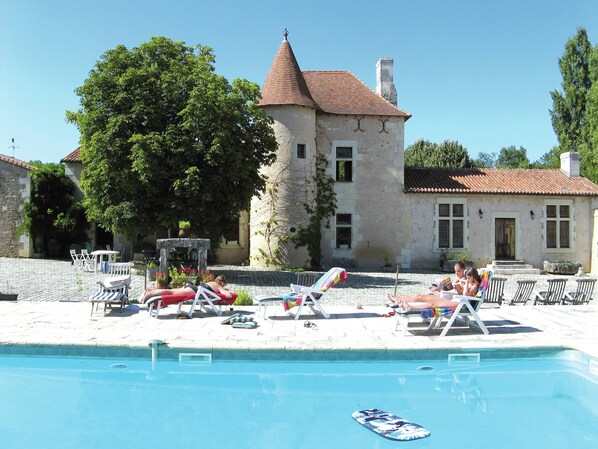 A poolside area with lounge chairs and a swimming pool.