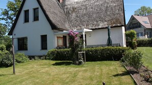 A traditional house with a steep thatched roof, white walls, and a small porch with a flower box. - Wohnung in Pepelow in Meeresnהhe (Pepelow)