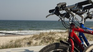 A bicycle parked on a concrete surface near a beach with the ocean in the background. - Wohnung in Pepelow in Meeresnהhe (Pepelow)