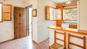 Una cocina con armarios de madera, una encimera y un ventanal.