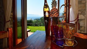 A wooden table with a bottle of champagne, a pineapple, and several glasses.