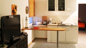 A compact kitchen with a TV, a coffee maker, a toaster, and a sink. - Bungalow auf der Insel Poel for 2 Personen (Insel Poel)