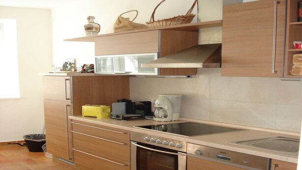 A modern kitchen with a built-in oven, a coffee maker, and a microwave.