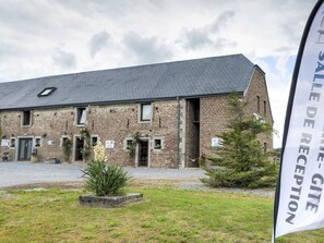 A brick building with a sloped roof, multiple windows, and a gravel driveway. - Group accommodation for families in Houyet (Houyet)