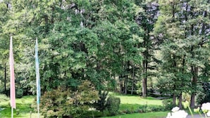 Un parc avec des arbres, un chemin pavé et des parterres de fleurs.