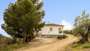 A rural house with a dirt road leading to it, surrounded by trees and vegetation. - Casa La Loma with Pool (Andalucía)