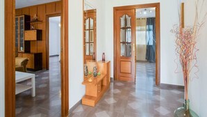 A hallway with a wooden bench, a mirror, and a vase with branches. - Casa La Loma with Pool (Andalucía)