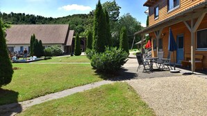 A courtyard with a pool, outdoor seating, and a building with a tiled roof. - Wohnung in Huddingen mit Terrasse (Bad Wildungen)