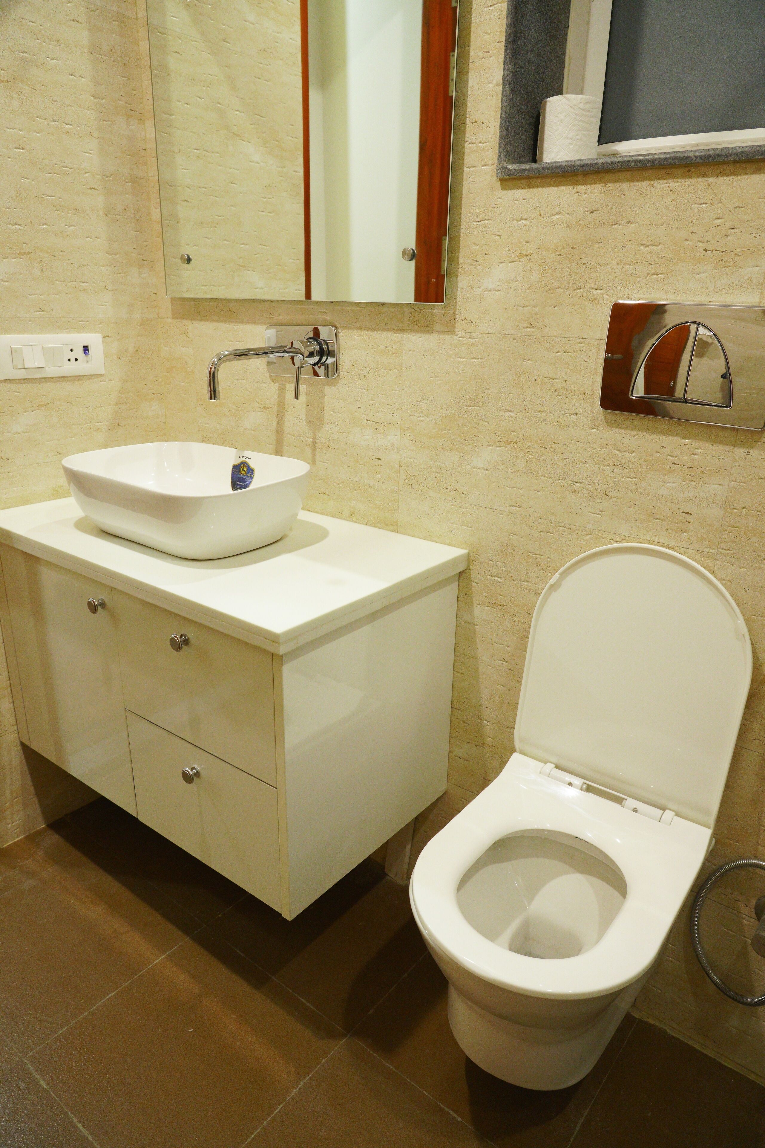 A bathroom with a white sink, a toilet, and a mirror above the sink.