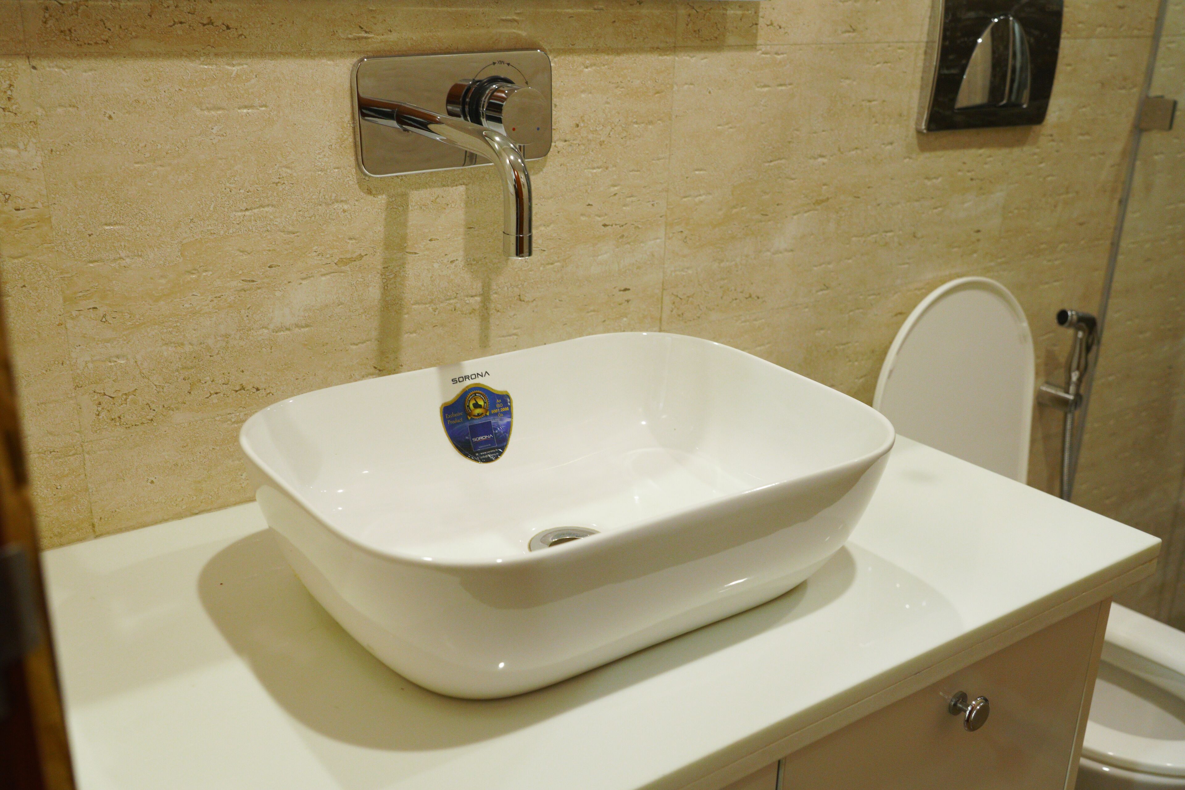 A bathroom with a white sink, a mirror, and a toilet.