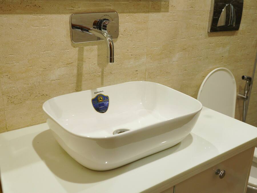 A bathroom with a white sink, a mirror, and a toilet.